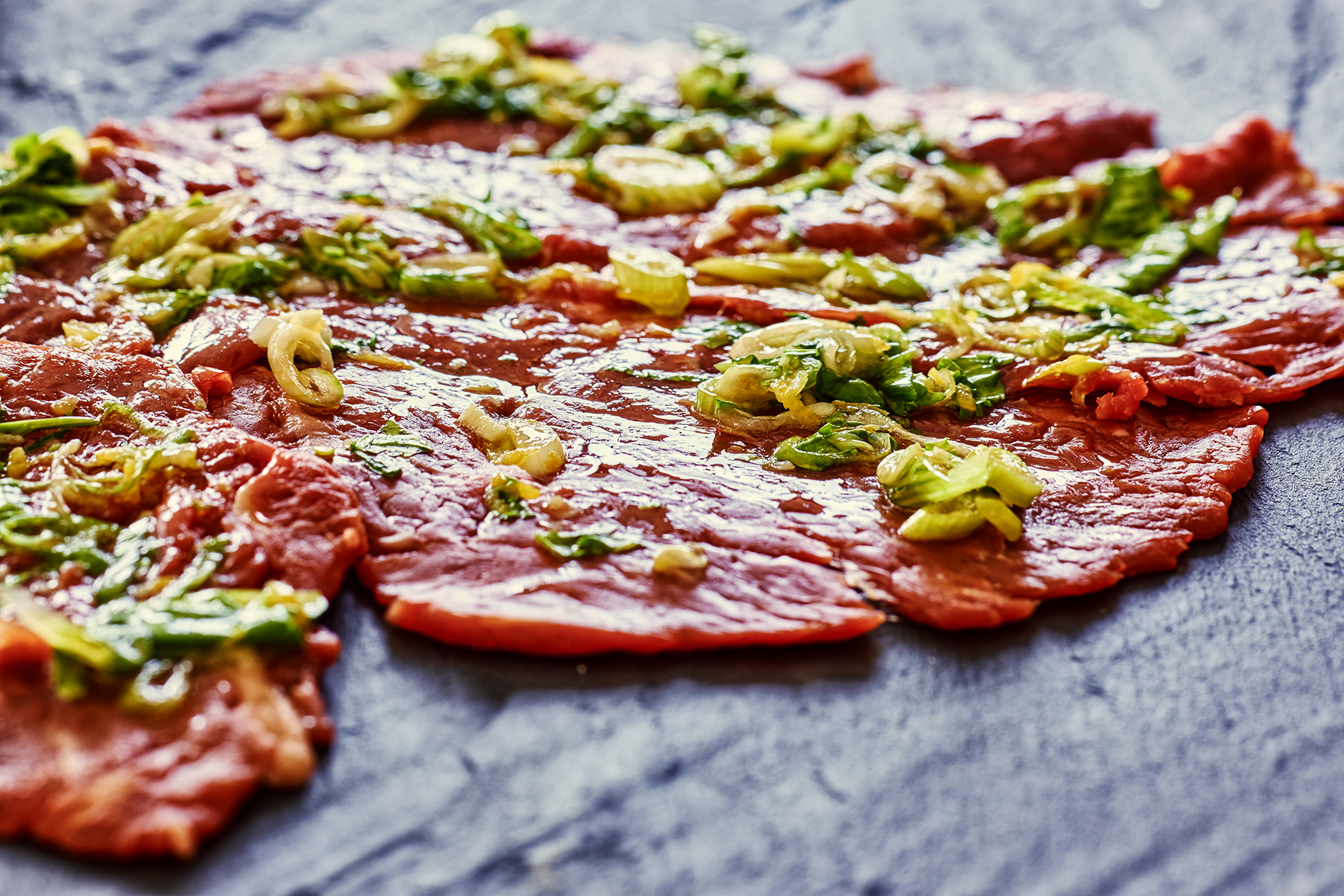 Raw marinated beef with lemongrass and rocket