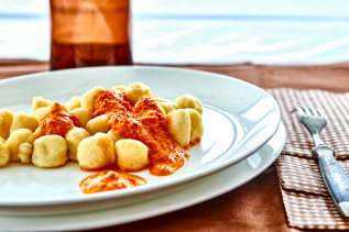 Gnocchi serviert auf einem weißen Teller mit Paprikasoße